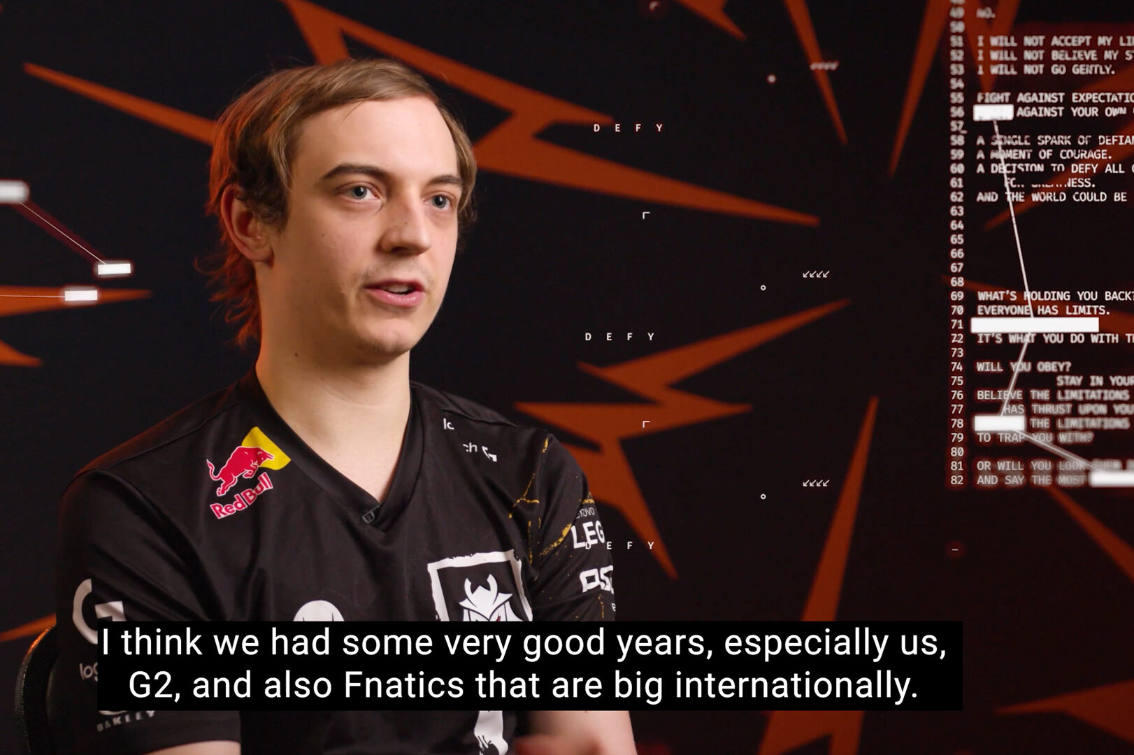 A young man in a G2 Esports jersey speaks in an interview, with angular orange graphics and text in the background. Subtitles read: “I think we had some very good years, especially us, G2, and also Fnatics at Riot Games MSI.”.