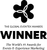 A stick figure is sitting at a desk, staring at a computer screen with a blank expression, coffee mug in hand—perhaps pondering ideas for an immersive marketing agency. The drawing is simple and black-and-white with minimal details.