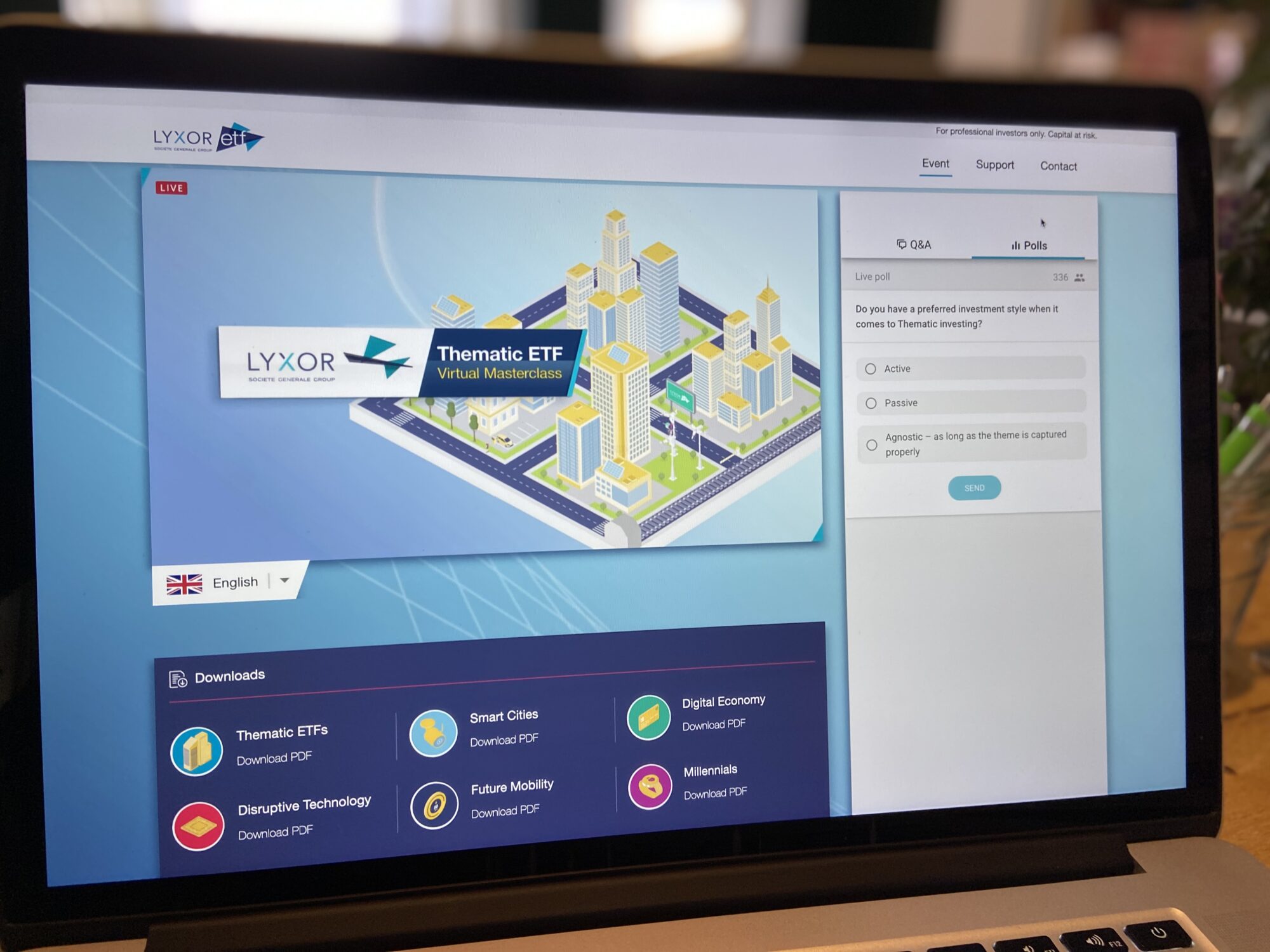A laptop screen displays a Lyxor ETF case study during a virtual event, featuring a digital city graphic, event options, language selection, Q&A poll, and download links for PDFs on Smart Cities and the Digital Economy.