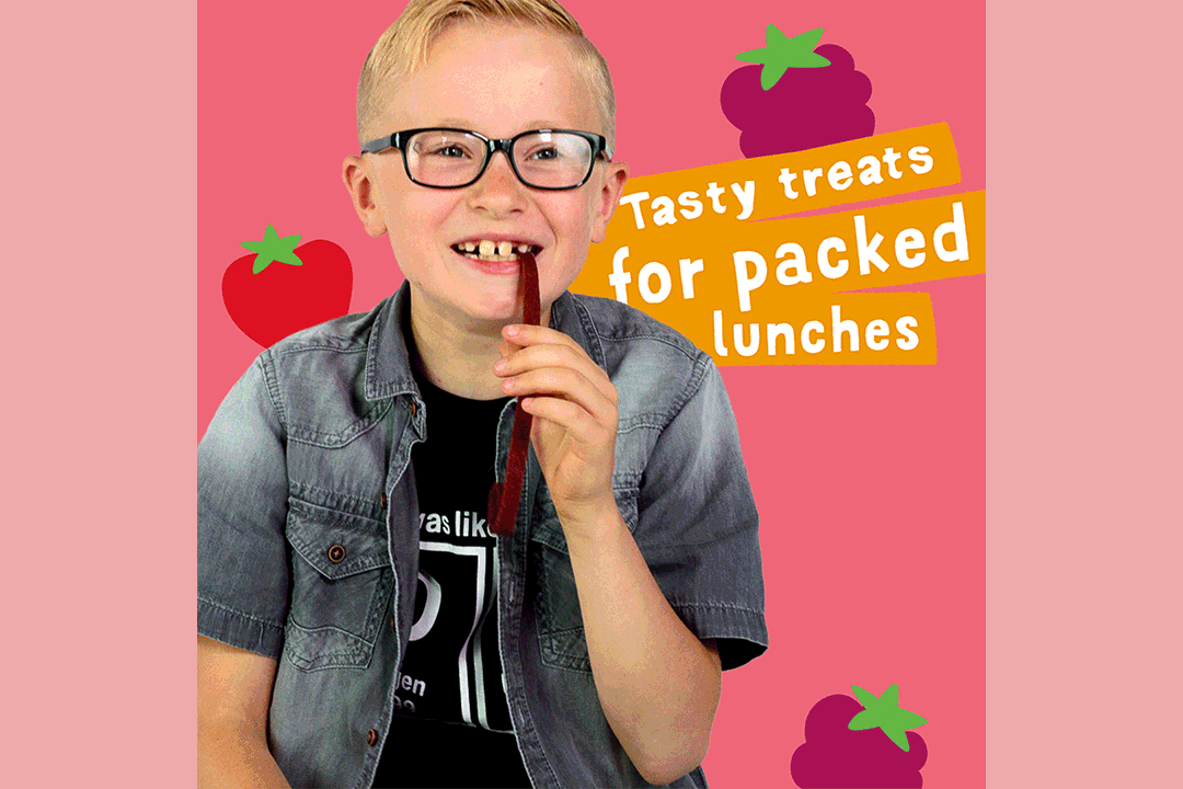 A smiling young boy with glasses eats a fruit stick. Behind him are colorful fruit illustrations and text that reads: Tasty treats for packed lunches. The pink background highlights this Bear Nibbles case study.